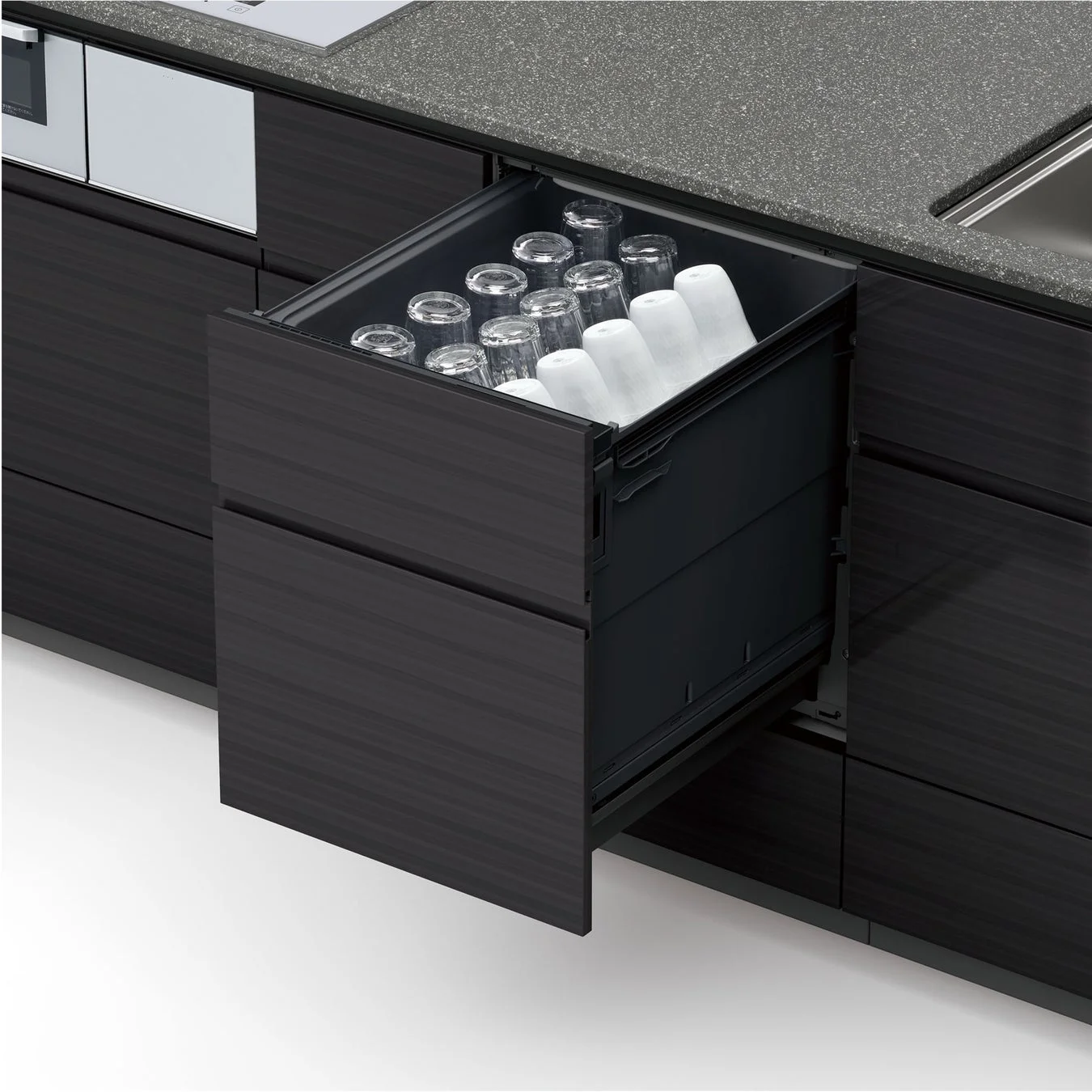 モダンなキッチンの引き出しが開き、透明なグラスと白いコップが整然と並べられています。