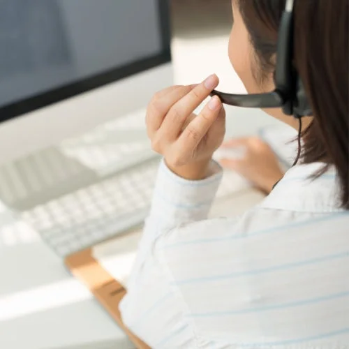 ヘッドセットを装着しパソコンに向かう女性