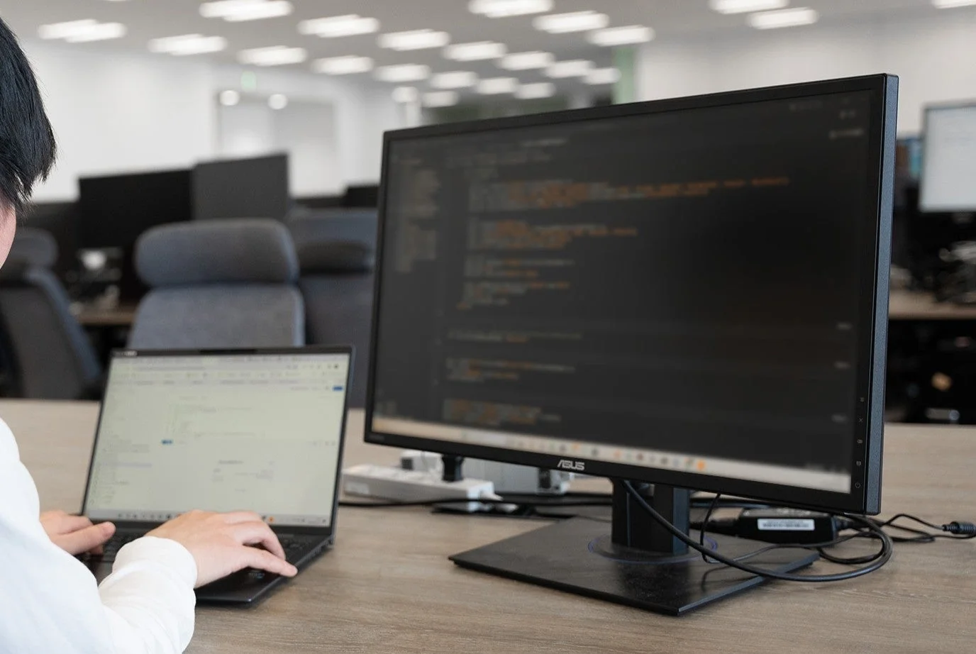 プログラミングコードが表示されたモニターを見つめるエンジニア