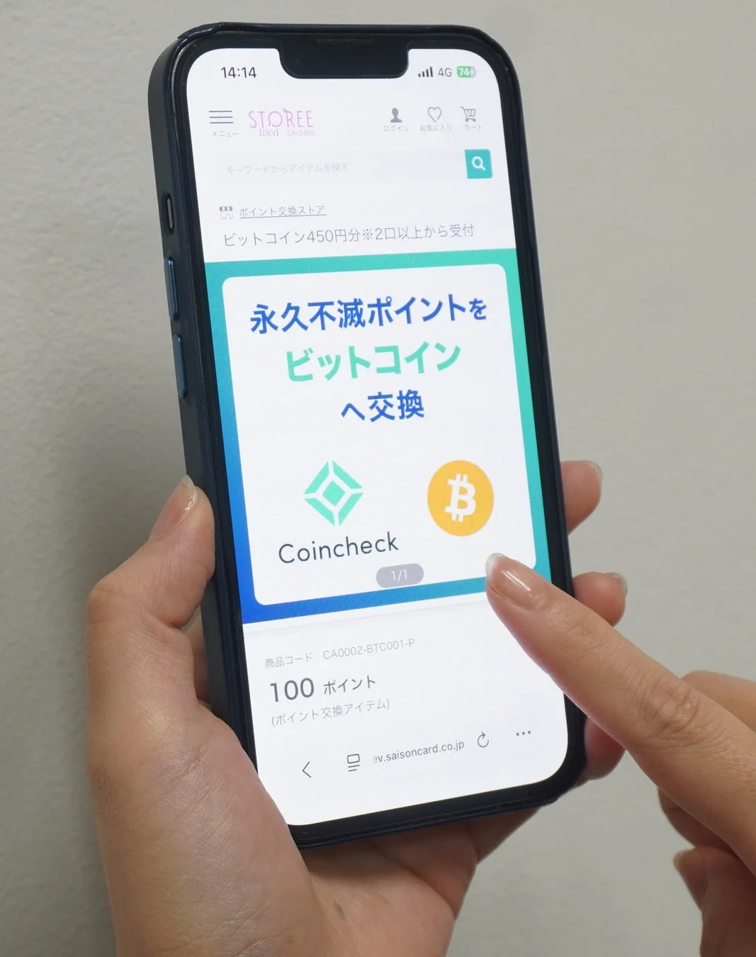 スマートフォンで「STOREE」アプリが表示され、永久不滅ポイントをビットコインに交換する画面